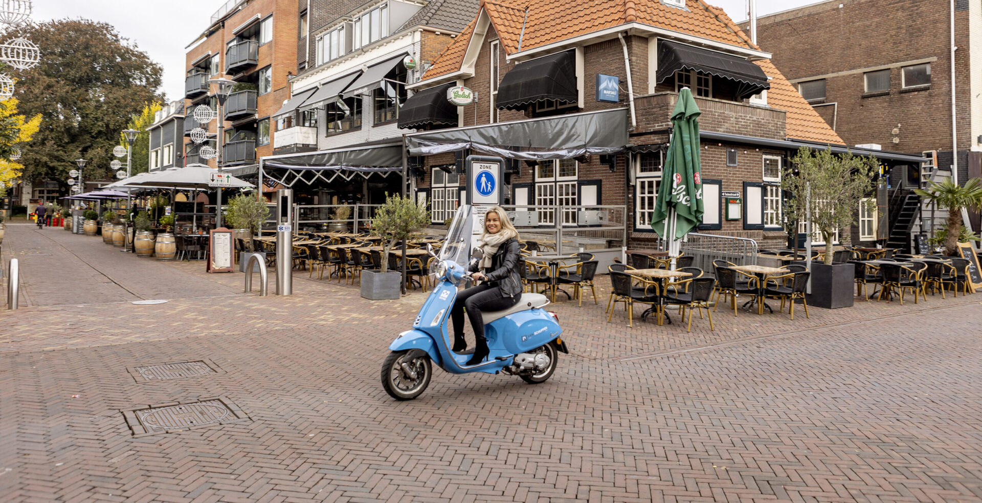 Danielle Diepeveen op Van Schuppen Makelaars scooter in centrum van Veenendaal